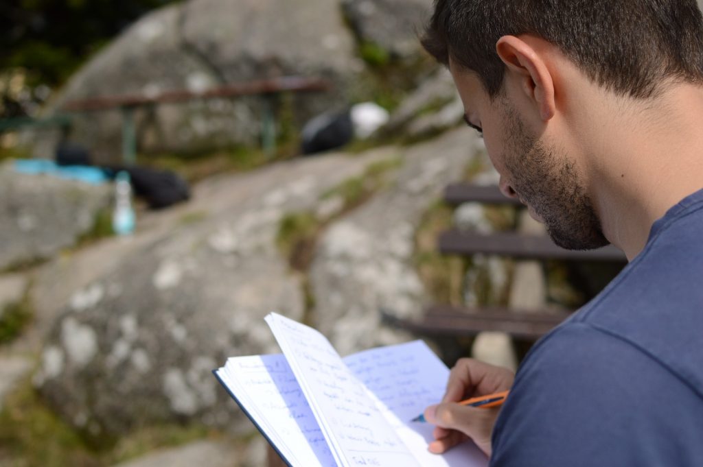 man writing down his thoughts on a piece of paper