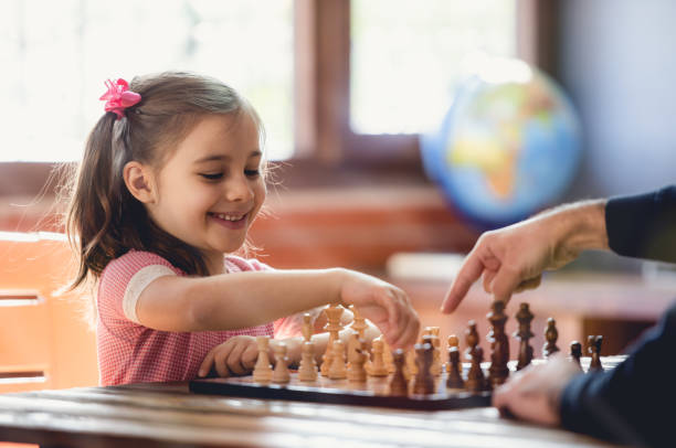 Girl smiling and playing chess with a tutori