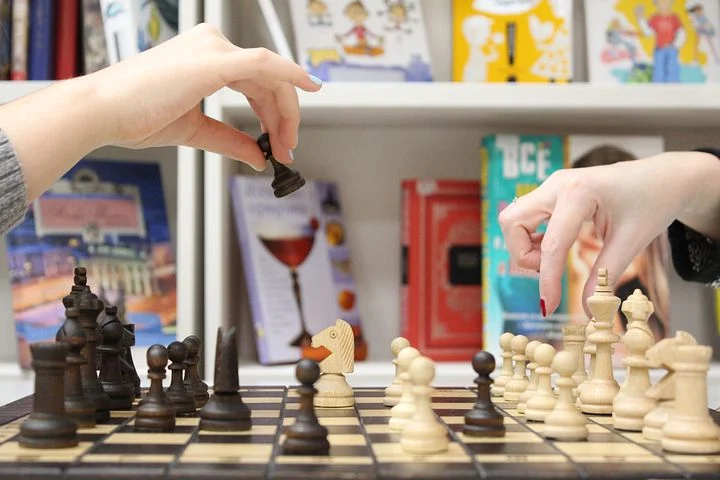 Two female hands playing a game of chess
