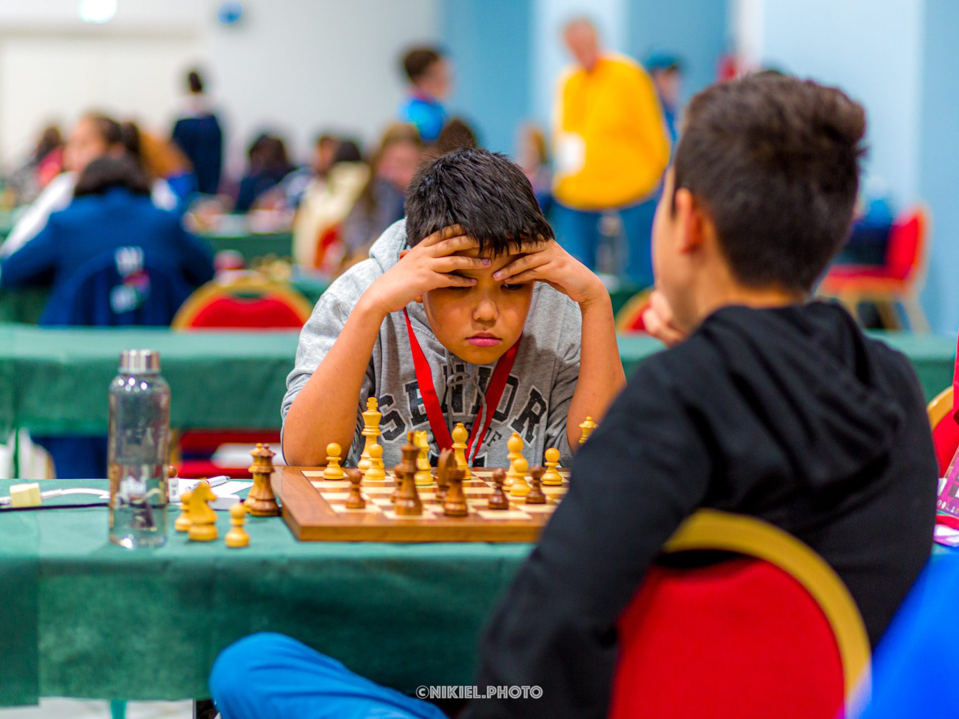 Boy thinking and playing chess against opponent