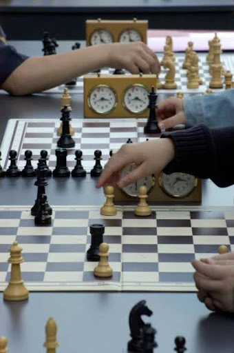 How to Improve in Chess Without a Coach 3 People playing chess in tournaments