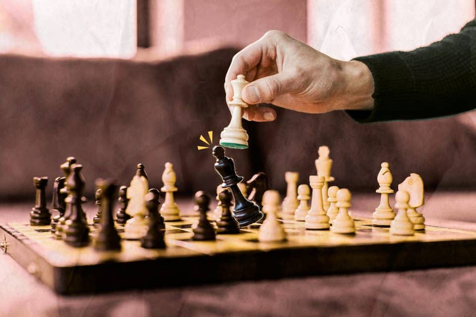 White queen knocking over Black King on chess board