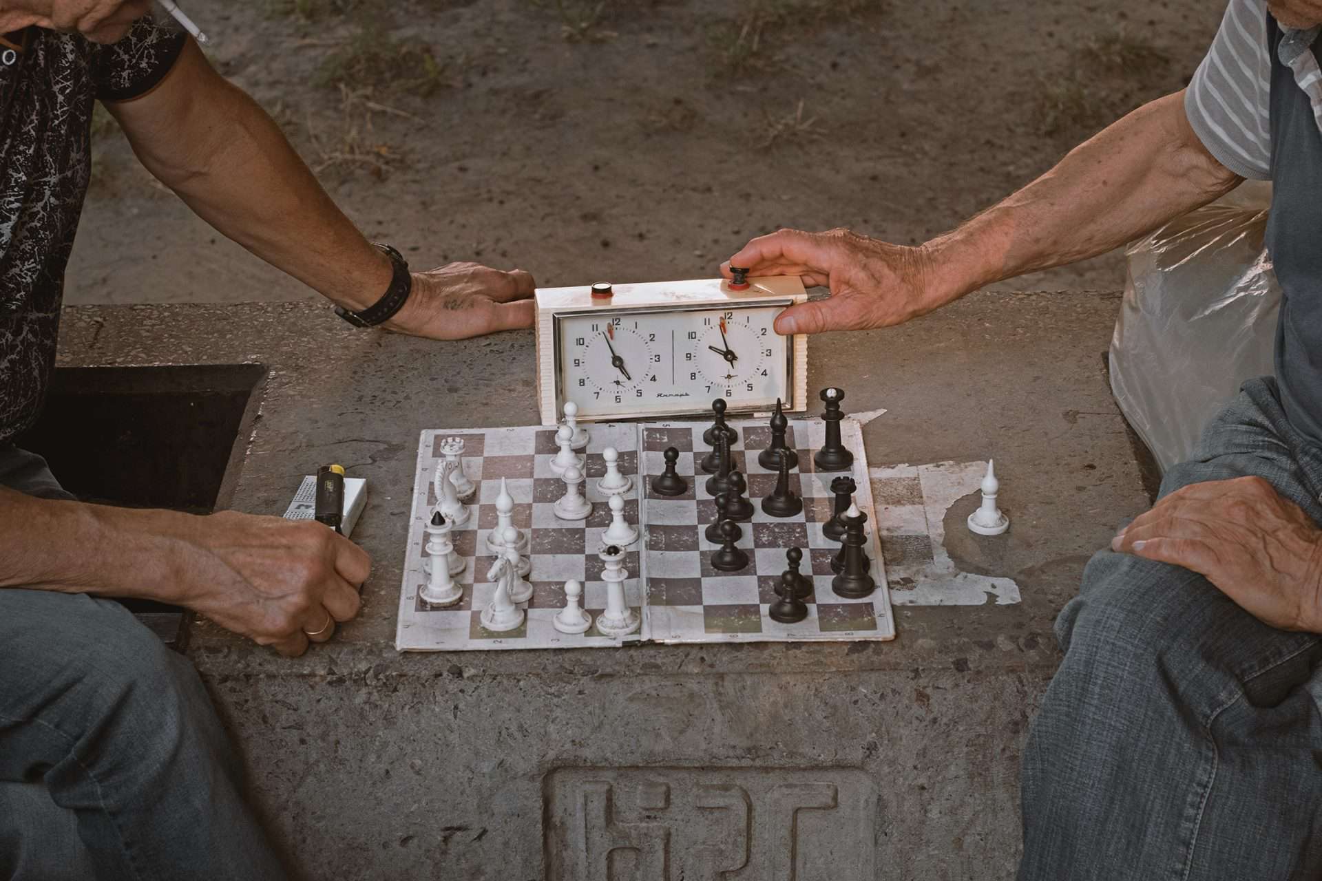 Two chess players playing chess and using an analog chess timer