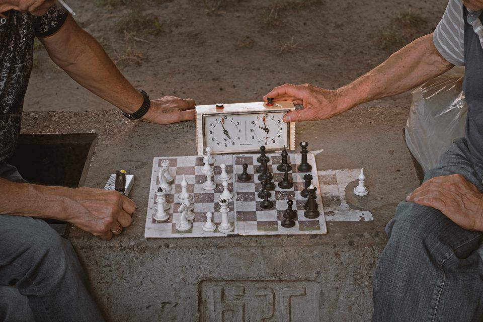 Two chess players playing chess and using an analog chess timer