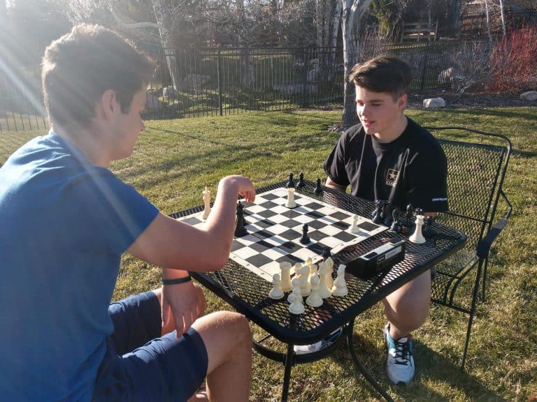 Two friends playing chess outdoors